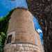 ...caratterizzata da una torre cilindrica in mattoni chiari con merlatura sommitale dentellata che affianca il monumentale ingresso